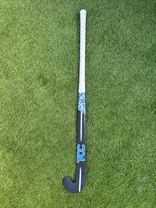 Black TCC Hockey stick on a grass field front view