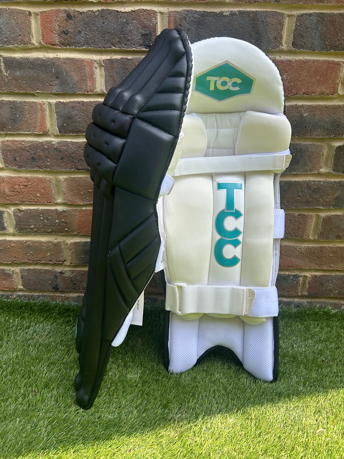 TCC Premium Black Batting Pads with Teal Logo positioned for side on and inside pad view with Logos on show