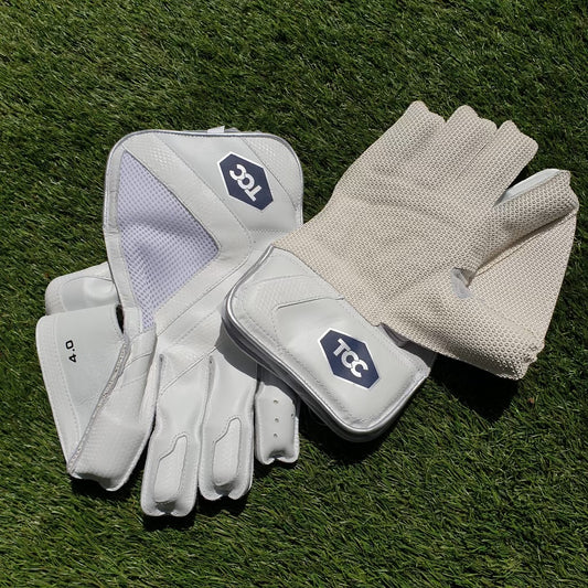 TCC Wicket keeping gloves laid out on the grass showing the palm and octopus grip