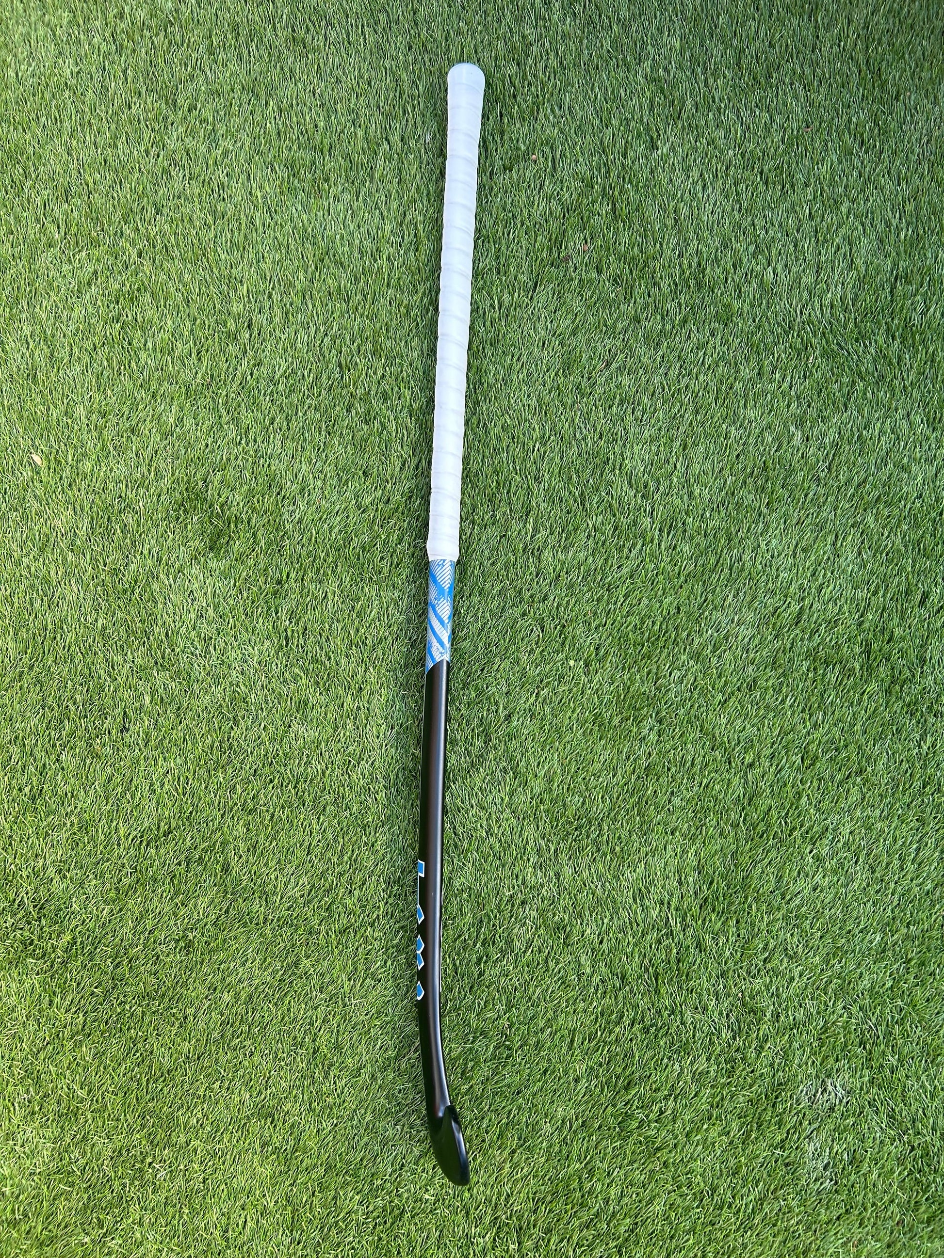 TCC Black Hockey stick on a green grass surface profile view to show bow