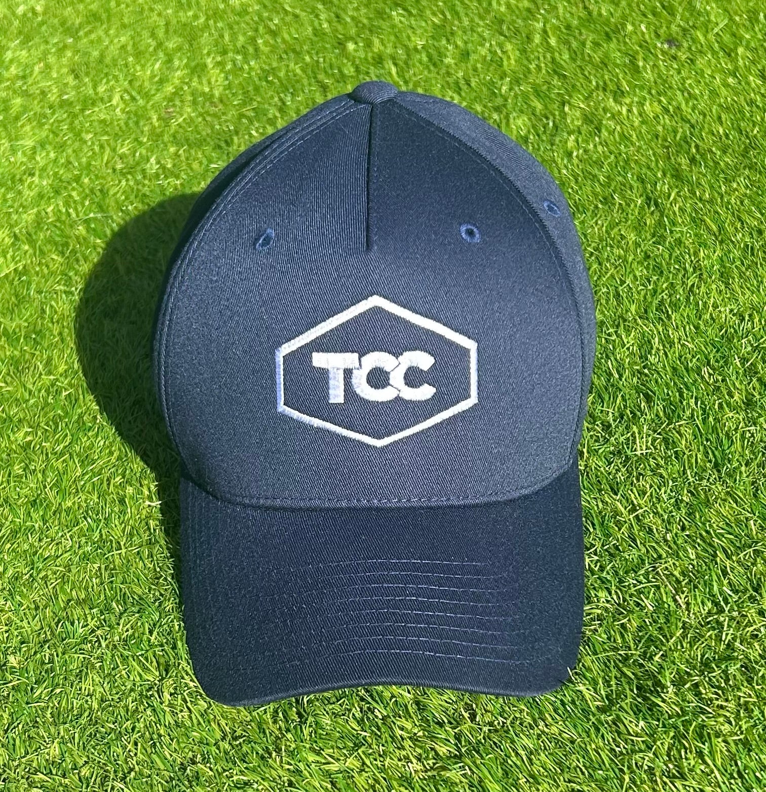 TCC Flexi Fit Cap Navy front view pictured on grass in sunshine