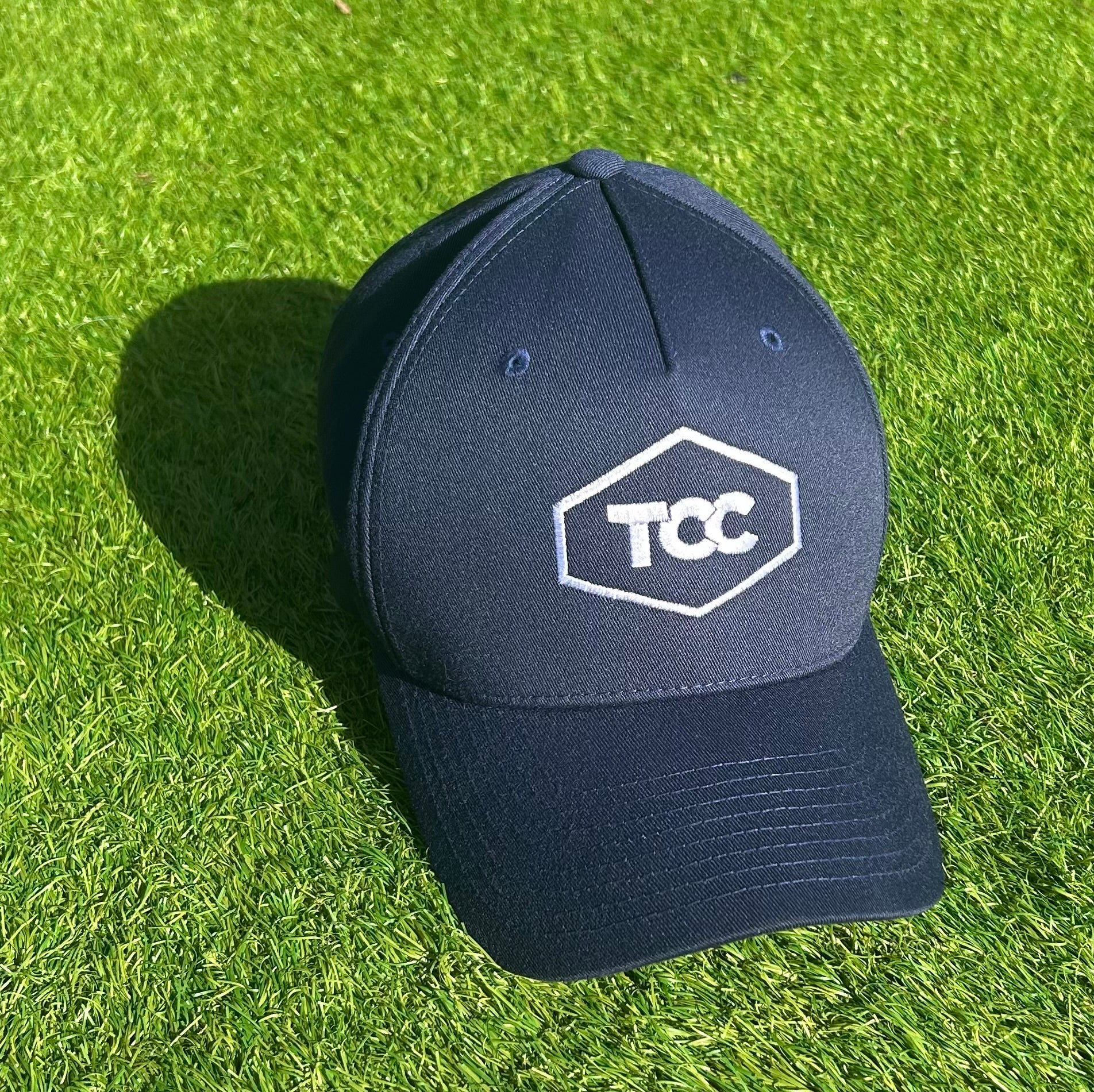 TCC Flexi Fit Cap in Navy pictured on grass in sunshine