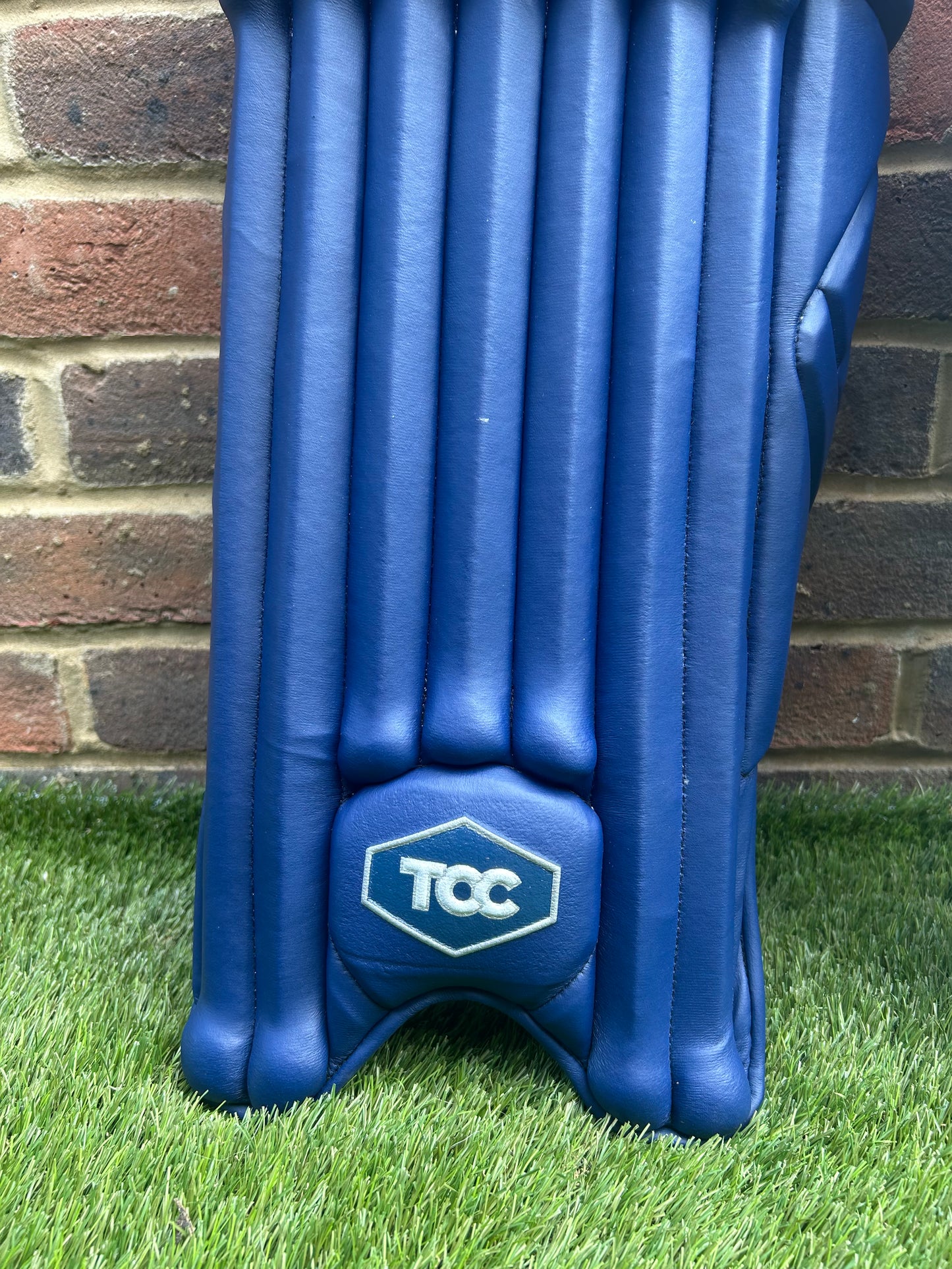 TCC Premium Navy Batting Pads feature of Navy Logo on front of pad